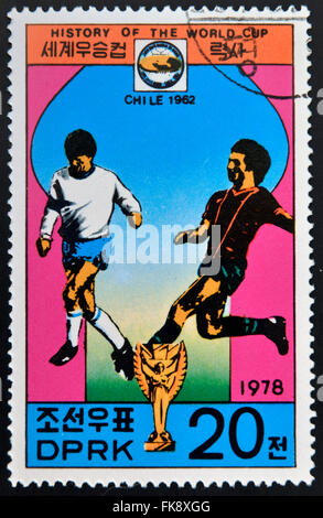 Corée - circa 1978 : timbre imprimé en Corée du Nord montre les joueurs de football, tasse et Glob avec l'inscription 'Chile, 1962' Banque D'Images