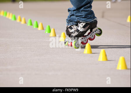 Skater évitant les obstacles sur le terrain dans le parc Banque D'Images