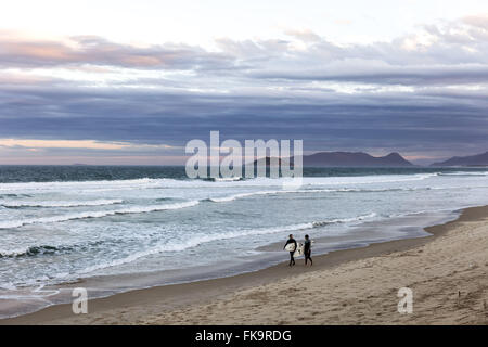 Surfeurs à Joaquina Plage au crépuscule Banque D'Images