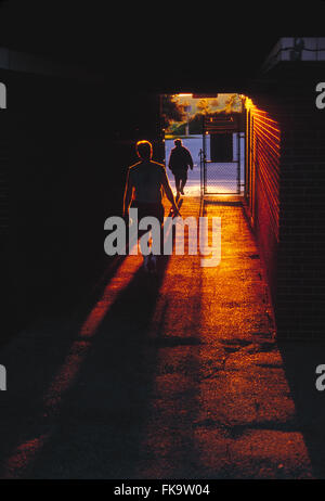 Coucher du soleil illumine coureurs homme quitter la piste du stade through tunnel Banque D'Images