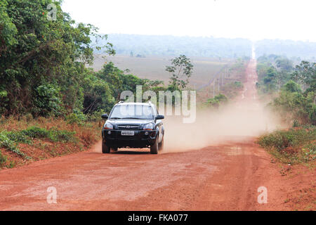 Voyage automobile sur l'autoroute 220 à MT-tronçon de chemin de terre en forêt amazonienne en arrière-plan Banque D'Images