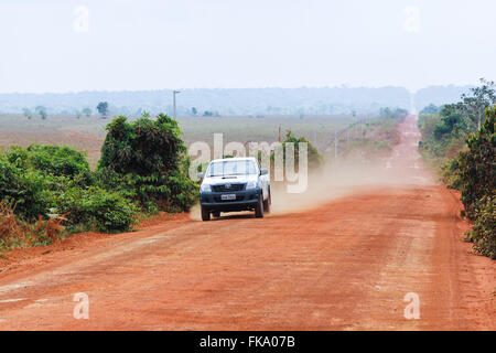 Voyage automobile sur l'autoroute 220 à MT-tronçon de chemin de terre en forêt amazonienne en arrière-plan Banque D'Images