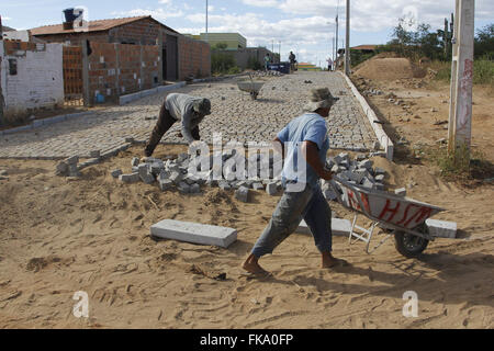 Coopératives travaillant dans le pavage de rue dans paralelepipedo en plein soleil Banque D'Images