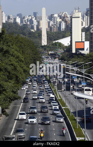 Trânsito de veículos na Rua 23 de Maio com Obelisco e Parque Ibirapuera ao fundo Banque D'Images