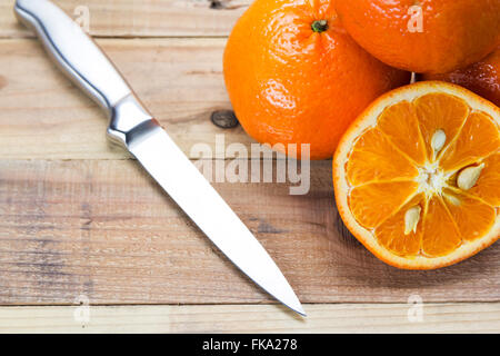 Les oranges fraîches à bol en bois. Sur un fond de bois. Banque D'Images