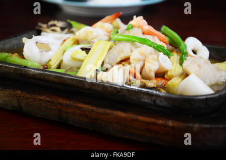 Sauté de légumes mélangés avec des fruits de mer en sauce aux huîtres servi sur la poêle chaude Banque D'Images