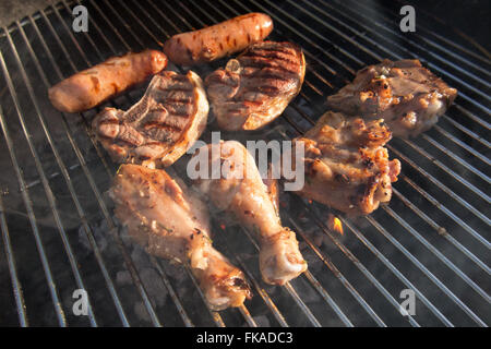 Griller la viande sur le barbecue, NotonFest, Milborne Port, Somerset, England, UK Banque D'Images