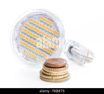 Ampoule LED avec de l'argent européen (close-up shot) sur fond blanc Banque D'Images