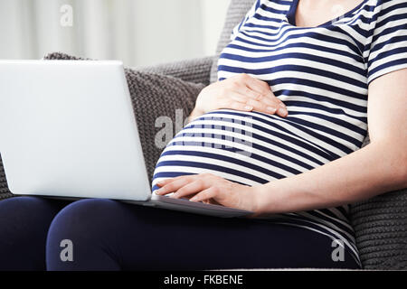 Close Up of pregnant woman Using Laptop At Home Banque D'Images