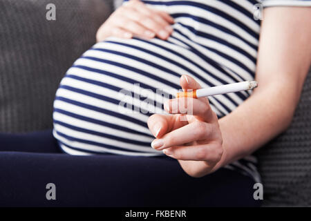 Close Up of pregnant woman smoking Cigarette Banque D'Images