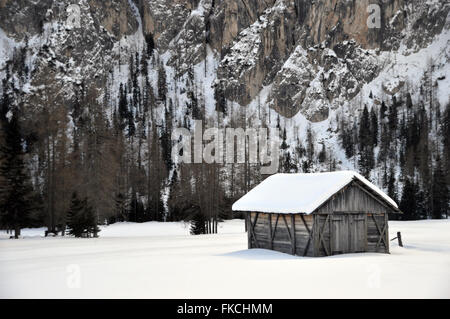 Chalet de montagne traditionnel dans la neige prairie remplie de Corvara Dolomites italiennes Banque D'Images