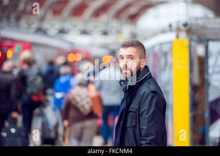 Homme Hipster en attente à la gare bondé Banque D'Images