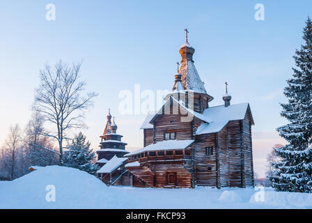 Église en bois en forêt d'hiver enneigé au coucher du soleil Banque D'Images