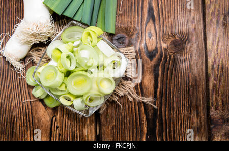 Partie de poireaux coupés frais sur fond de bois foncé Banque D'Images