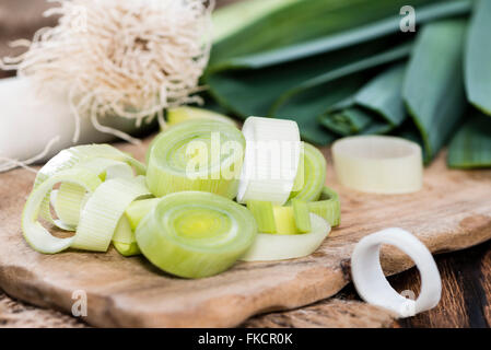 Partie de poireaux coupés frais sur fond de bois foncé Banque D'Images