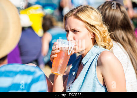 Jeune femme blonde avec de la bière au summer music festival Banque D'Images