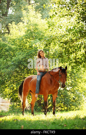 Femme rider sur l'arrière de son cheval à trail Banque D'Images