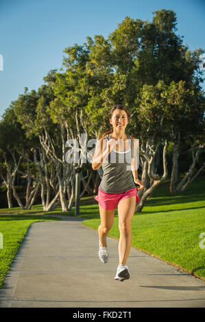 Young woman running in park Banque D'Images