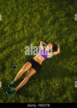 Young woman lying on grass Banque D'Images
