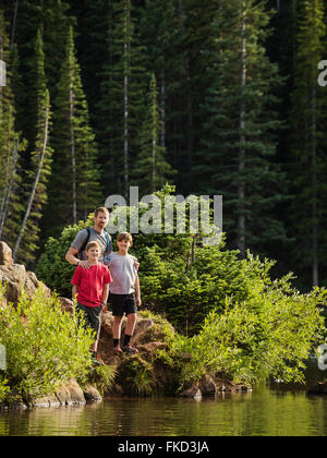 Père avec fils (10-11, 12-13) par lake Banque D'Images