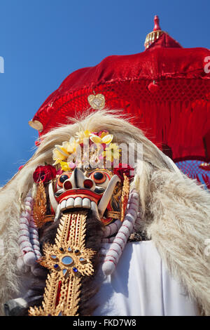 Masque Rangda sous parapluie rouge à temple esprit traditionnel de Bali lors d'une cérémonie Melasti avant Nouvel An balinais et le silence jour Banque D'Images