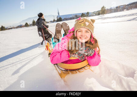 Enfants (8-9, 10-11) jouant avec la neige en traîneau Banque D'Images