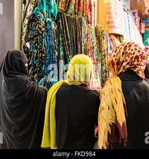 Trois femmes, 1 en tchador, et 2 dans la tête de foulards colorés chiffon navigation en vente au bazar Vakil, Shiraz, Iran Banque D'Images