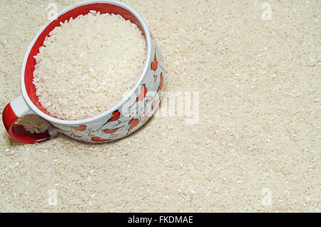 Background Les grains de riz sur la surface, et une tasse Banque D'Images