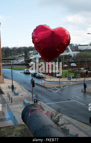 Ballon rouge attaché à un canon sur Derry avec le Pont de la paix dans l'arrière-plan Banque D'Images