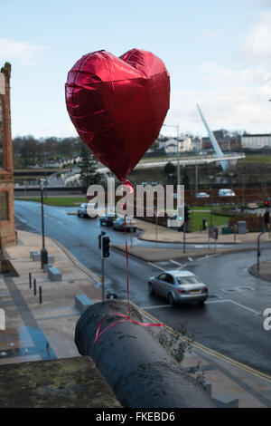 Ballon rouge attaché à un canon sur Derry avec le Pont de la paix dans l'arrière-plan Banque D'Images