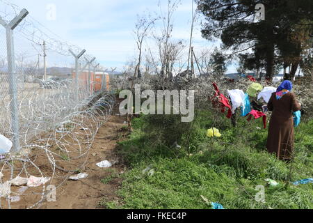 Idomeni, Grèce. 8 mars, 2016. Une femme tend à gauche à chiffons secs à la camp de fortune à la frontière de la Macédoine grecque, près du village de Idomeni, où des milliers de réfugiés et migrants sont bloqués. Credit : Orhan Tsolak/Alamy Live News Banque D'Images