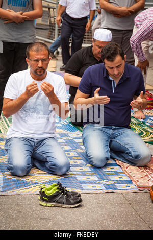 Prier les musulmans lors de la prière du vendredi dans une rue près de la Place Taksim, Istanbul, Turquie Banque D'Images