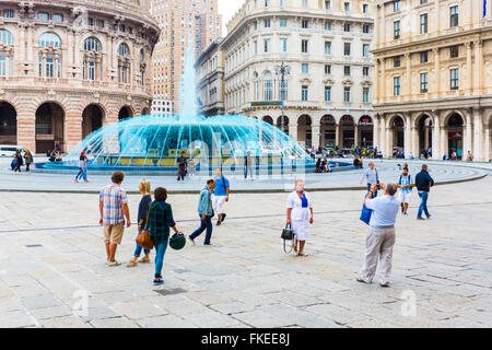 Les touristes à la place de Ferrari et fontaine avec l'eau bleue (en couleur pour célébrer le boat show) à Gênes Ligurie Italie Banque D'Images