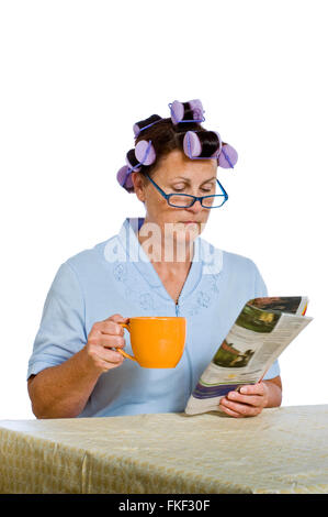 Woman Reading paper et Holding Coffee Cup Banque D'Images