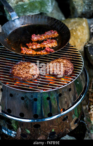 Pattys et bacon sur un grill Banque D'Images