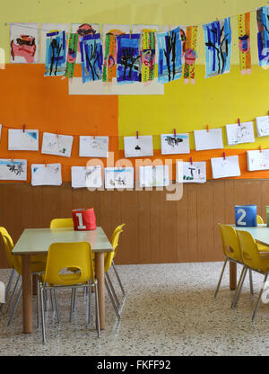 Classe de maternelle avec les chaises jaunes et des dessins d'enfants Banque D'Images