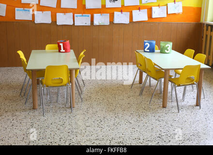 Classe de maternelle avec les chaises jaunes et de nombreux dessins d'enfants sur les murs Banque D'Images