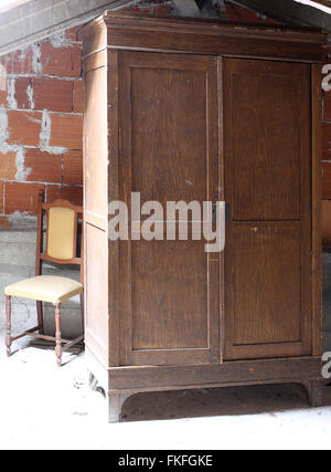 Meubles anciens en armoire dans le grenier poussiéreux de la vieille maison et une vieille chaise Banque D'Images