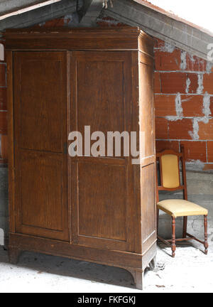 Meubles anciens en armoire dans le grenier poussiéreux et une vieille chaise Banque D'Images