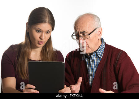 Jeune femme et homme senior chating avec la famille using tablet computer Banque D'Images