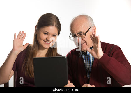 Jeune femme et homme senior chating avec la famille using tablet computer Banque D'Images