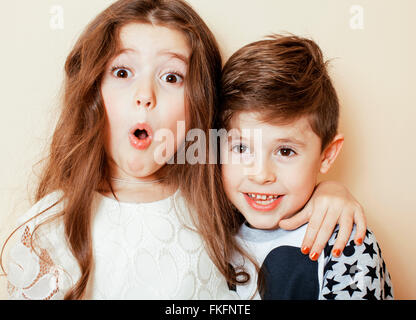 Peu cute boy and girl hugging jouant sur fond blanc, happy family smiling Banque D'Images