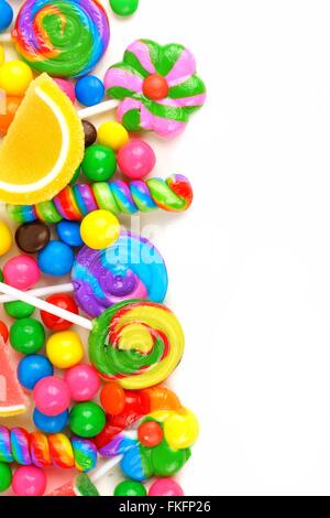 La frontière du côté d'un assortiment de bonbons colorés sur un fond blanc. Banque D'Images