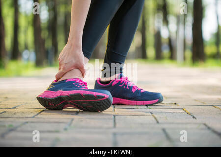 Woman runner tenir la douleur de cheville tordue ,Human Foot crampon Banque D'Images