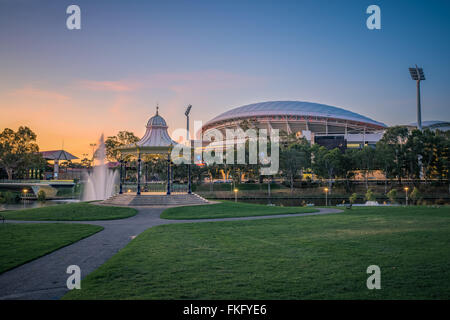 Coucher du soleil dans la Cité des rives avec la rotonde ornée Elder Park flanquée de l'Adelaide Oval, récemment modernisé. Banque D'Images