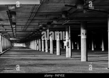 Une image en noir et blanc du parc de stationnement abandonné situé à un niveau inférieur à l'aéroport de Mirabel (CYMX) à Mirabel, au Québec, au Canada. Banque D'Images