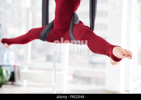 Libre de jambes de jeune femme faisant la ficelle sur hamac dans aerial yoga studio Banque D'Images