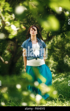 Femme enceinte en méditant sur la nature. Portrait pleine hauteur, les yeux fermés. Focus sélectif. Banque D'Images