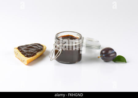 Pot de confiture de prunes, de prune et de tranche de baguette sur fond blanc Banque D'Images