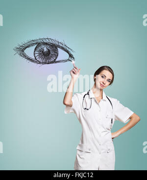 Femme médecin en uniforme touch peint oeil humain Banque D'Images